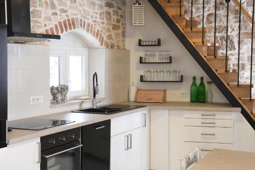 una cocina con armarios blancos y un aparato negro en Villa Arte, en Bale