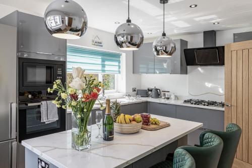 a kitchen with a counter with a vase of flowers at Clydfan in Holyhead