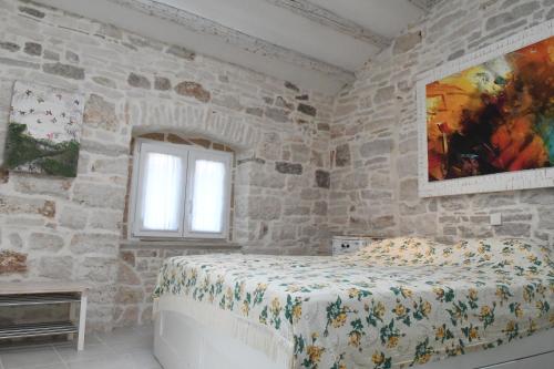 a bedroom with a bed in a stone wall at Villa Arte in Bale