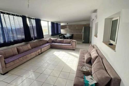 uma sala de estar com dois sofás e um sofá em Chez Sarah em Beni Khiar