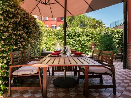 a wooden table with chairs and an umbrella on a patio at Ca' Mazzega in Murano