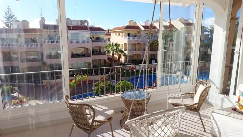einen Balkon mit Stühlen und Blick auf ein Hotel in der Unterkunft Tenerife Golf Park Apartment in San Miguel de Abona