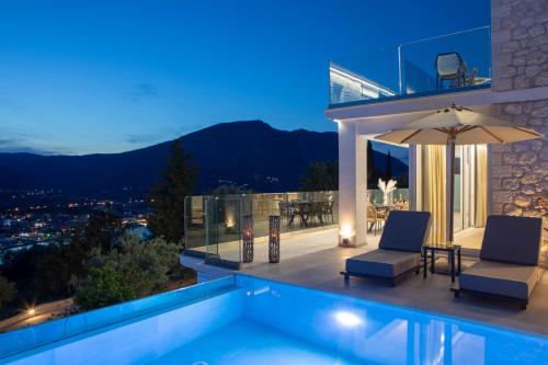 a villa with a swimming pool at night at MAJESTIC VILLAS in Yenion