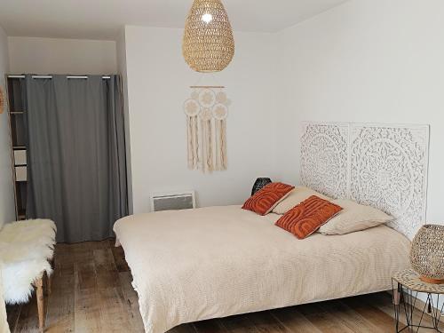 1 dormitorio con 1 cama con almohadas de color naranja en la bouée rose, en Sangatte