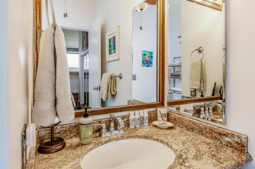 La salle de bains est pourvue d'un lavabo et d'un miroir. dans l'établissement A Little Aloha, à Kailua-Kona