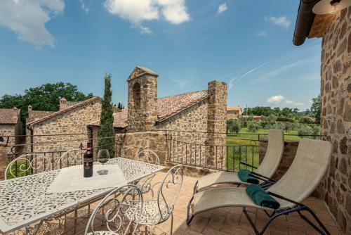 a patio with a table and chairs on a balcony at Castel Brunello in Montalcino