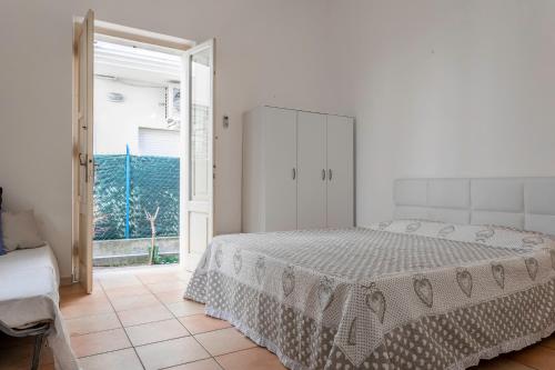 una camera bianca con un letto e una porta scorrevole in vetro di Saporedimare - Affittacamere fronte mare - Narramondo Villas a Tortoreto