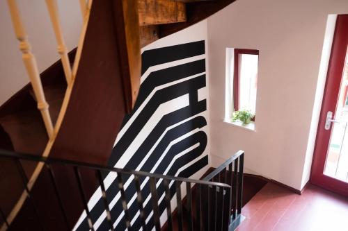 a staircase with a black and white striped wall at Arbio I Lax Apartments in Leipzig