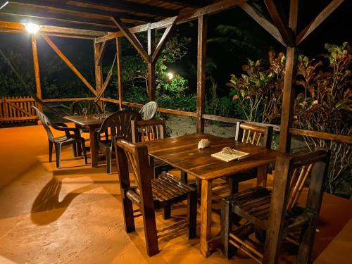 a wooden table and chairs on a porch at night at Mompiche Island Hostel in Mompiche