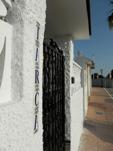 a sign on the side of a building with a gate at Casa Tarca Gran Alacant in Alicante