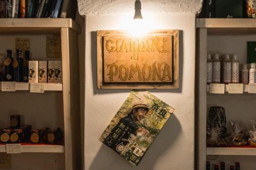 a sign on a wall next to a shelf with books at Ostello dei Giardini di Pomona in Cisternino