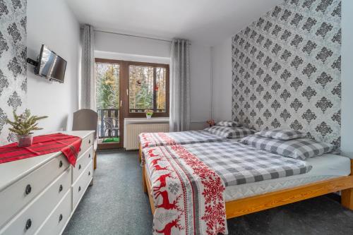 ein Schlafzimmer mit einem Bett und einer Kommode in der Unterkunft Willa Kaliniec in Karpacz