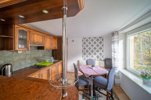 eine Küche mit einem Tisch und einigen Stühlen in einem Zimmer in der Unterkunft Willa Kaliniec in Karpacz