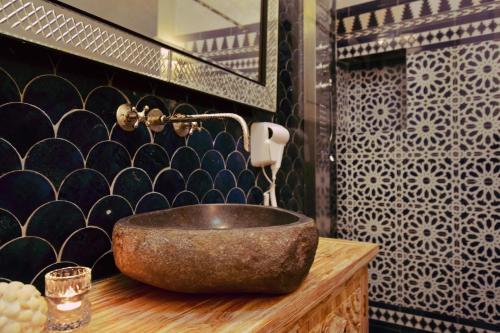 a bathroom with a stone sink on a wooden counter at Chapel 5 Boutique Suites B&B in Naxxar