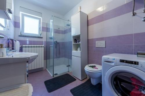 een paarse badkamer met een wasmachine. bij KARLO in Čavle