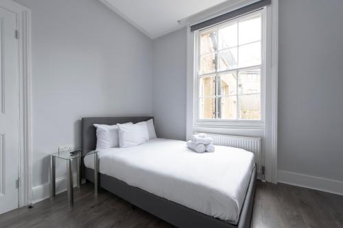 a bedroom with a bed with a teddy bear on it at Charming Character House London in London