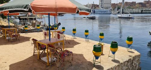 a beach with tables and chairs and an umbrella at La Terrace in Aswan