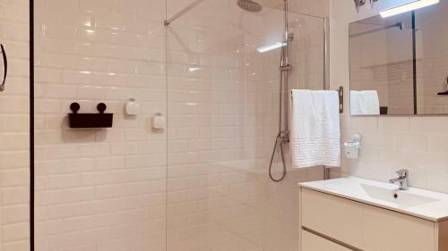 La salle de bains est pourvue d'une douche en verre et d'un lavabo. dans l'établissement LA BALLENERA, à Cangas
