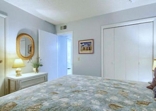a bedroom with a large bed and a mirror at Gulf Shores Plantation Condos in Gulf Shores