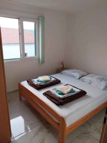 ein Schlafzimmer mit einem Bett mit zwei Handtüchern darauf in der Unterkunft Apartman Tamara in Sumartin
