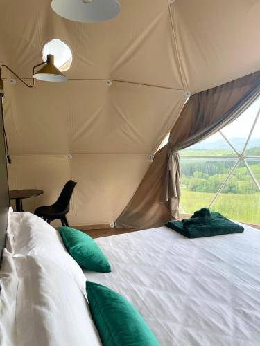 a bedroom with a bed in a tent with a window at Masseria Monte Pizzi Glamping Dome in Cerreto