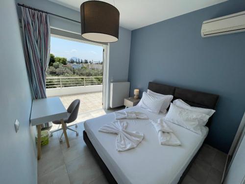 a bedroom with a bed with white sheets and a window at Luxury Villa Loutraki with private heated pool in Loutraki