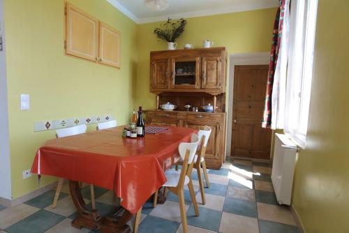 a kitchen with a table with a red table cloth at La Maison des Armas in Les Vans