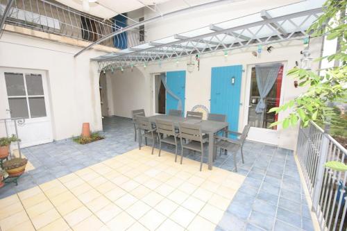 a patio with a table and chairs on it at La Maison des Armas in Les Vans