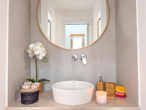 La salle de bains est pourvue d'une grande baignoire blanche et d'un miroir. dans l'établissement Bleisure Inn, à Cagliari