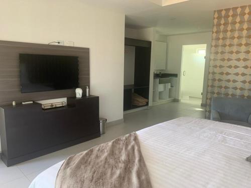 a bedroom with a bed and a flat screen tv at San Miguel Cabañas in Valle de Guadalupe