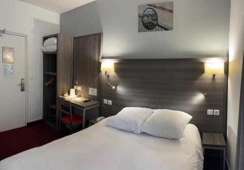 a hotel room with a bed and a desk and a bed sidx sidx sidx sidx at Hipotel Lilas Gambetta in Paris