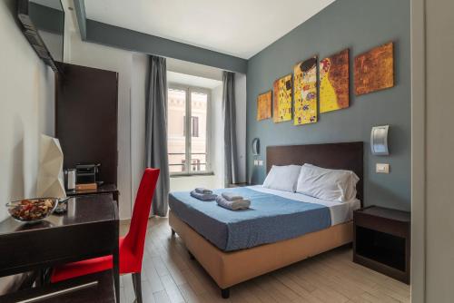a bedroom with a bed and a desk with a red chair at S.Marco Guesthouse in Rome