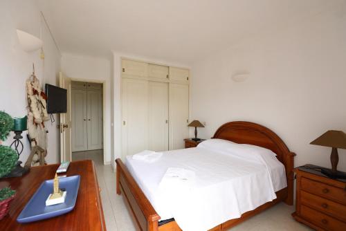 een slaapkamer met een bed en een bureau met een nachtkastje bij B60 - Lagos Promenade View Apartment in Lagos