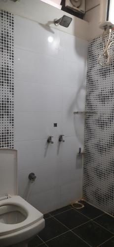 a bathroom with a white toilet and a shower at Kings Mysuru hotels - SGH in Mysore