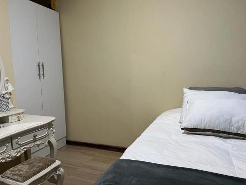 1 dormitorio con 1 cama y vestidor con espejo en Cosy & neat 1 bedroom apartment in Ibex Hill, Lusaka, en Lusaka