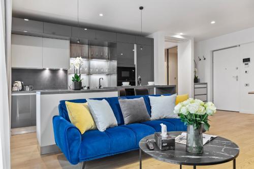 a living room with a blue couch and a kitchen at Aviation Tower Luxury Apartments in Bucharest