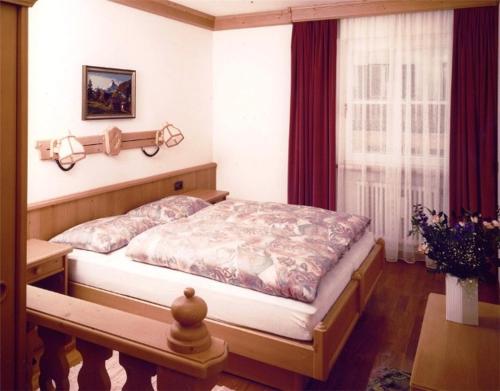 een slaapkamer met een bed en een raam bij Residence Unterhuber in San Candido