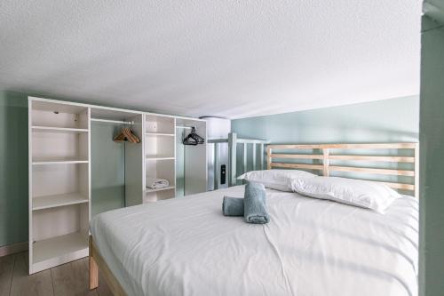 a bedroom with a large white bed and shelves at My CASA - SAINT SIAGRE 3 in Nice