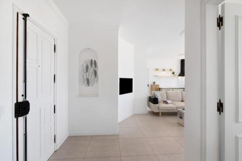a hallway with white walls and a room with a door at Lindo T2 com vista mar in Quarteira
