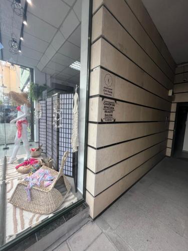 a store window with a woman walking past a building at Apartment City Park Sandanski in Sandanski