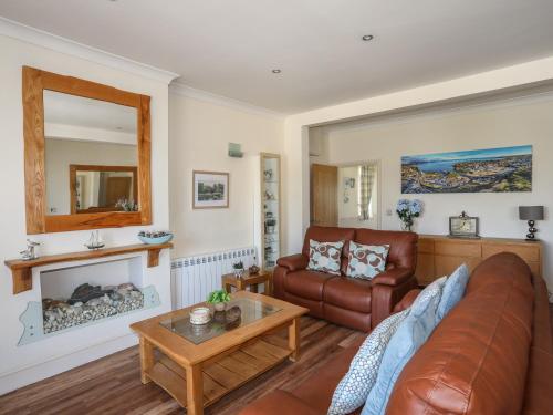 a living room with a couch and a fireplace at Harbour View in Abersoch