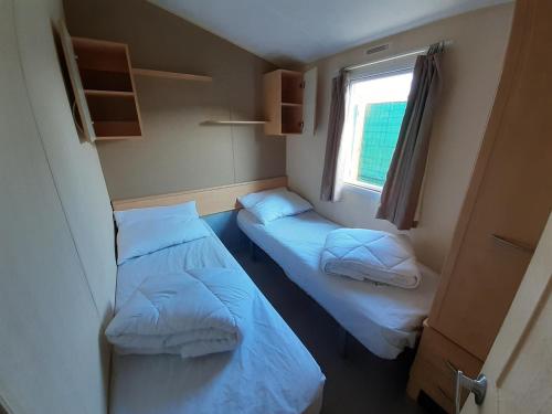 two beds in a small room with a window at Herbes de Pampa in Maringues