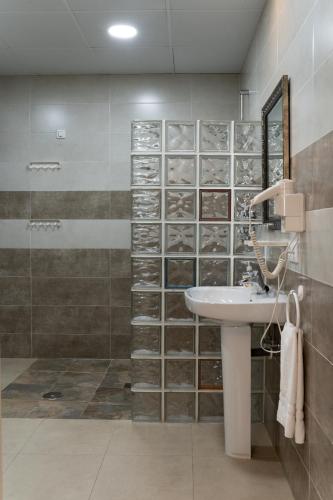 a bathroom with a sink and a shower at Hotel Alquimia Cadiz in Cádiz