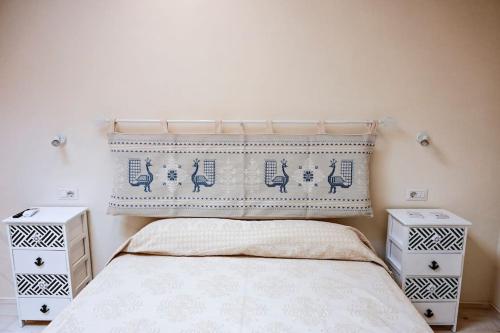 um quarto com uma cama com duas mesas de cabeceira em Grand Suite King Of Majorca Esclusiva su due livelli em Alghero