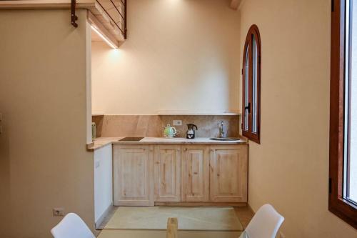 a kitchen with a sink and a counter with chairs at Grand Suite King Of Majorca Esclusiva su due livelli in Alghero