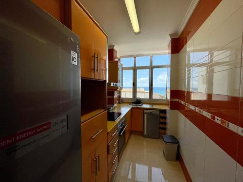 a kitchen with wooden cabinets and a large window at Las Canteras View Home in Las Palmas de Gran Canaria