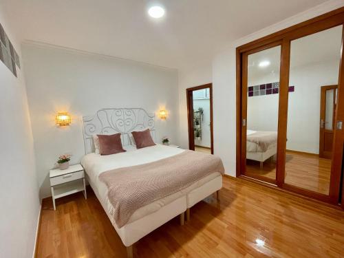 una camera con un grande letto e uno specchio di Las Canteras View Home a Las Palmas de Gran Canaria
