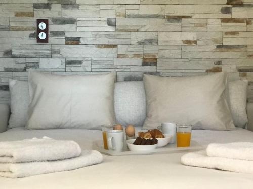 een wit bed met een dienblad met eten en drinken bij NATURE & SEA in Saronida