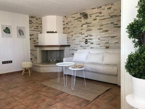 een woonkamer met een witte bank en een open haard bij NATURE & SEA in Saronida