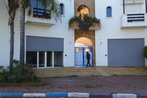 Ein Mann steht am Tor eines Gebäudes. in der Unterkunft Appartement à 2 minutes de la plage Skhirat in Skhirat